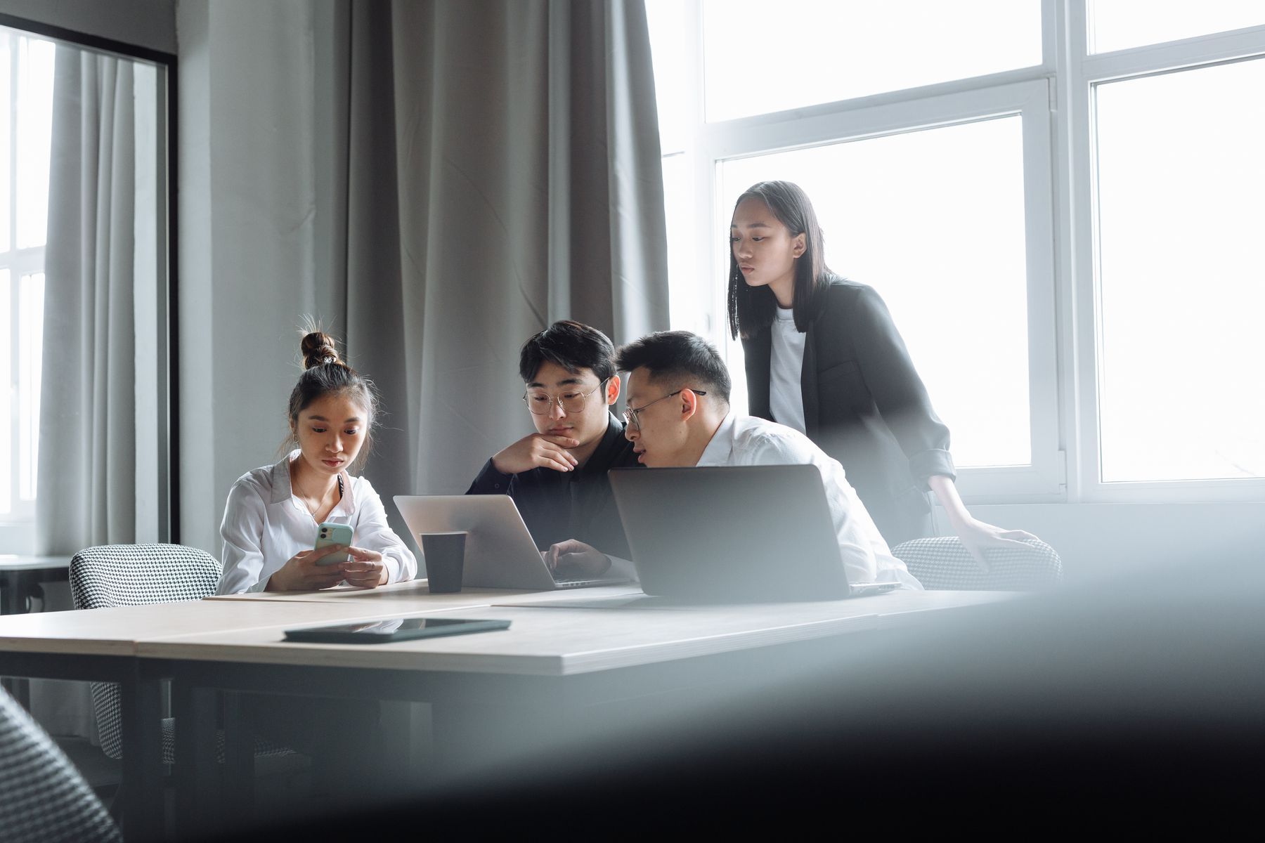 A team working together around laptops in a modern office